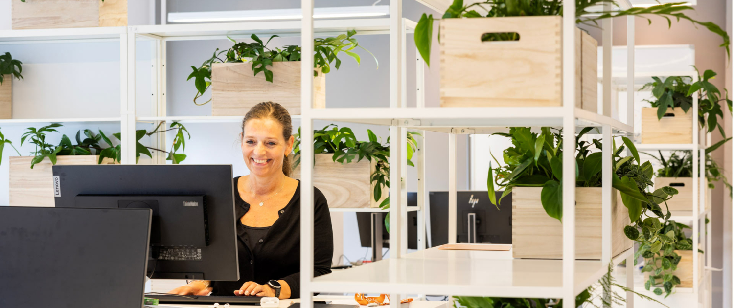 Dame smiler ved arbejdsplads